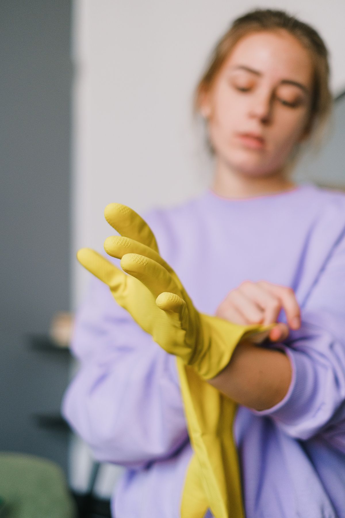 Person zieht Schutzhandschuhe an – Schutz vor zu viel Belastung bei Feuchtarbeit