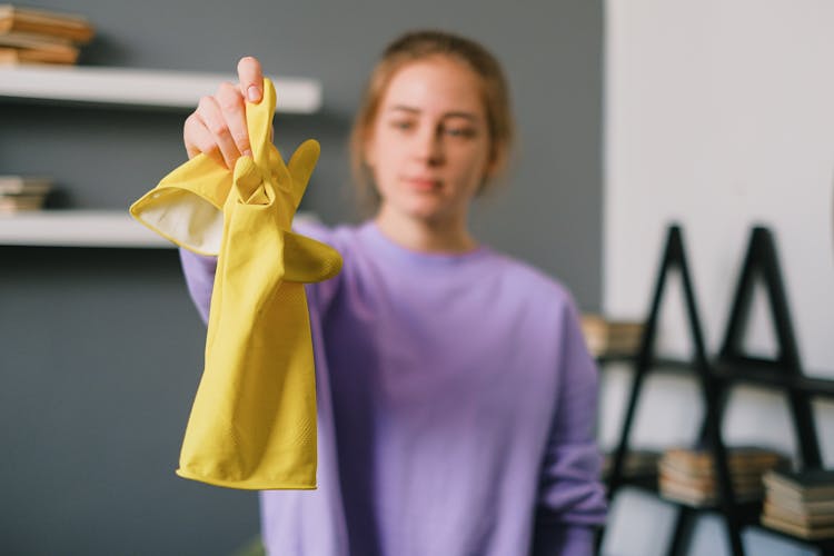 Female Reaching Out Hand With Latex Gloves In Room