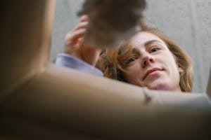 Positive woman unpacking box at home