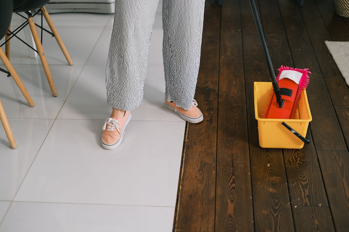 Faceless housewife preparing to wash floor at home