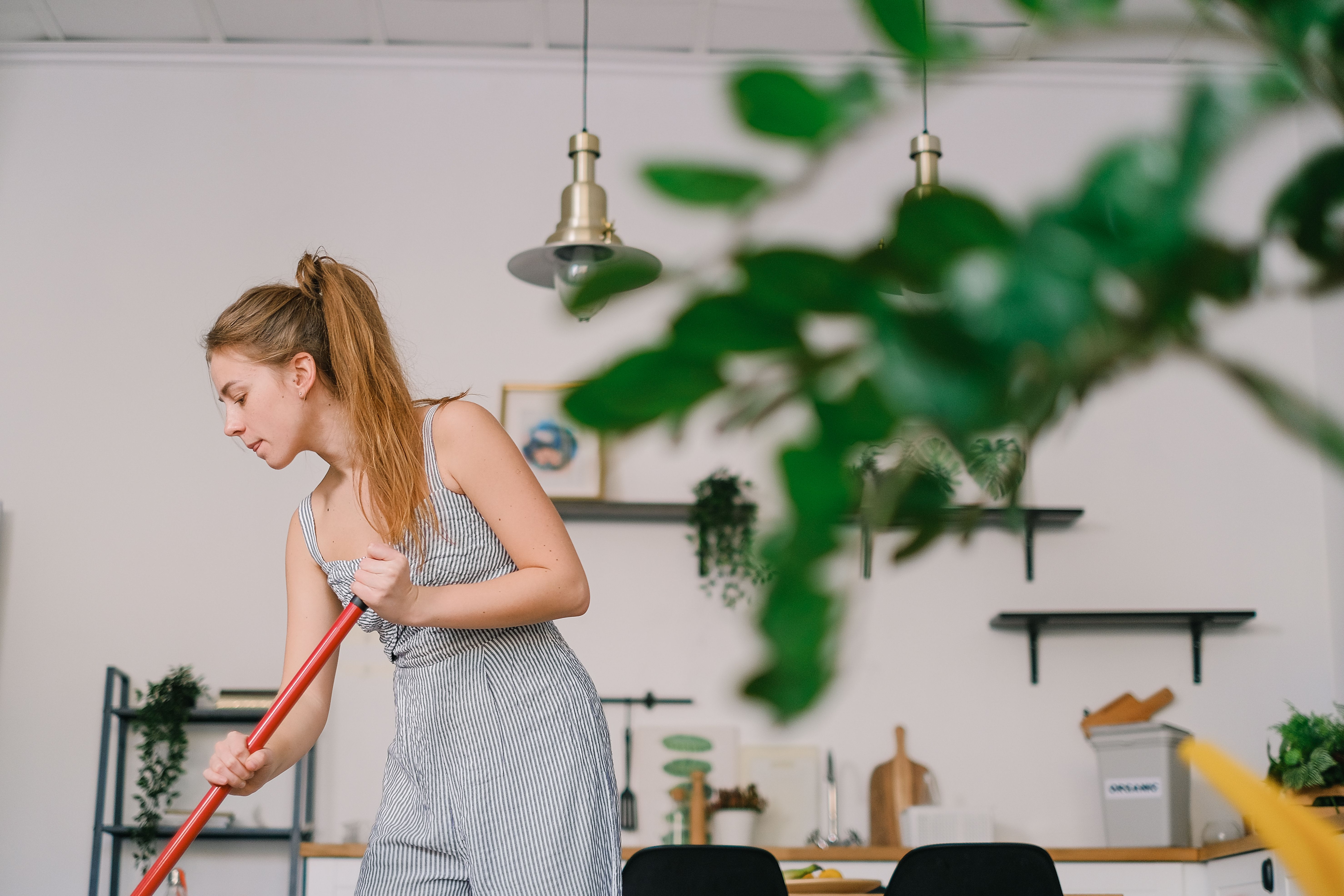 Woman mopping a kitchen floor during move-out cleaning