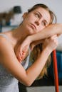 Tired housewife leaning on mop during housework