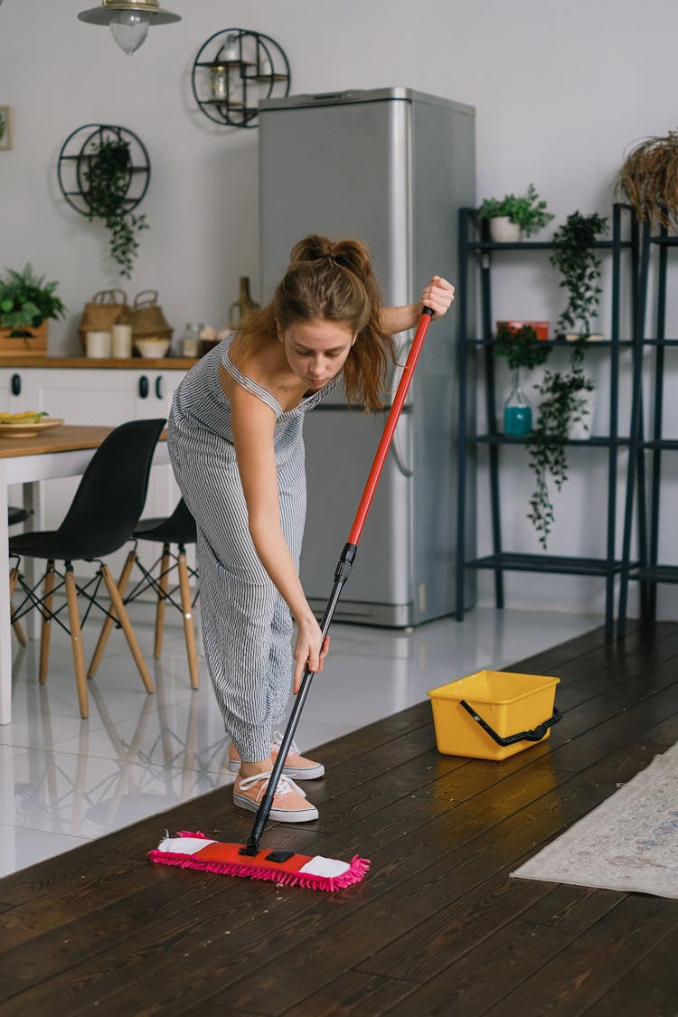 Housewife Cleaning Floor With Mop In Room