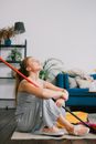 Housewife resting with crossed legs on carpet