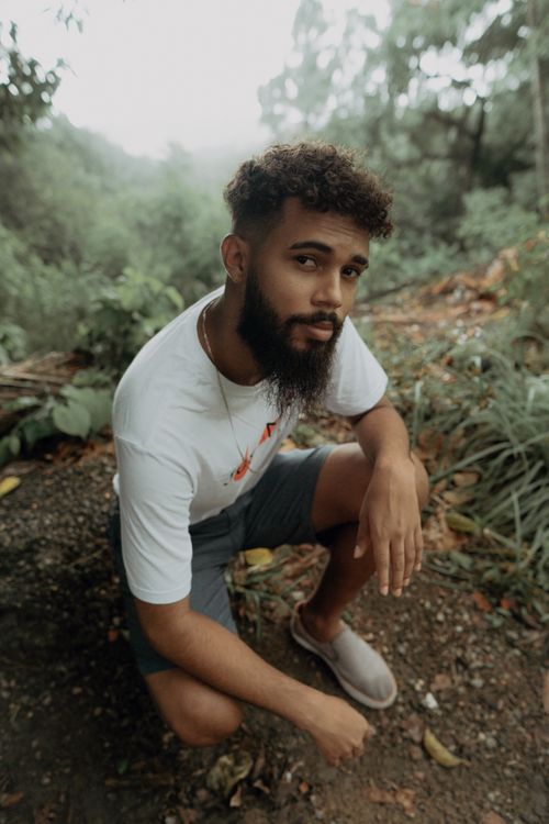 Free Fashionable young man posing thoughtfully in lush outdoors in Brazil. Stock Photo