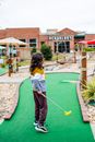 Unrecognizable girl playing golf against urban building