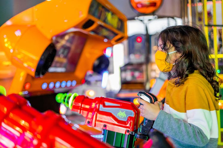 Attentive Girl In Respiratory Mask Playing Gaming Machine