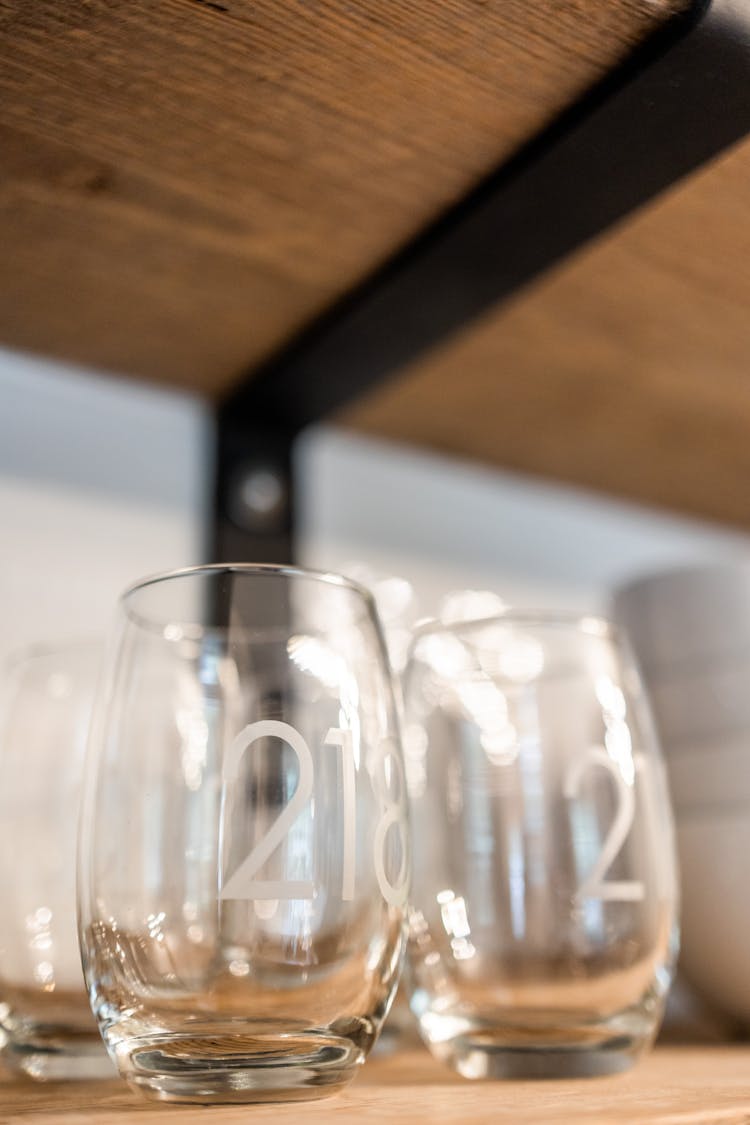 Glassware With Numbers On Shelf In Cafe