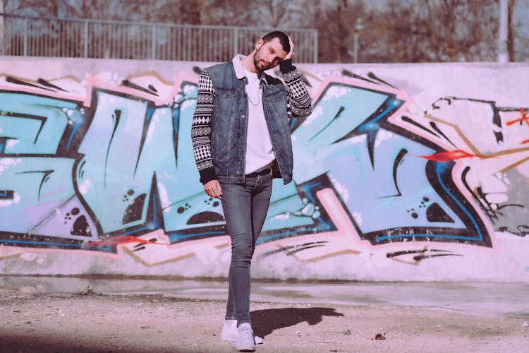 A Man Wearing A Sweater Under His Denim Vest