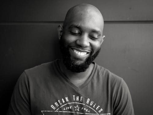 Grayscale Photo of a Bald Man Smiling
