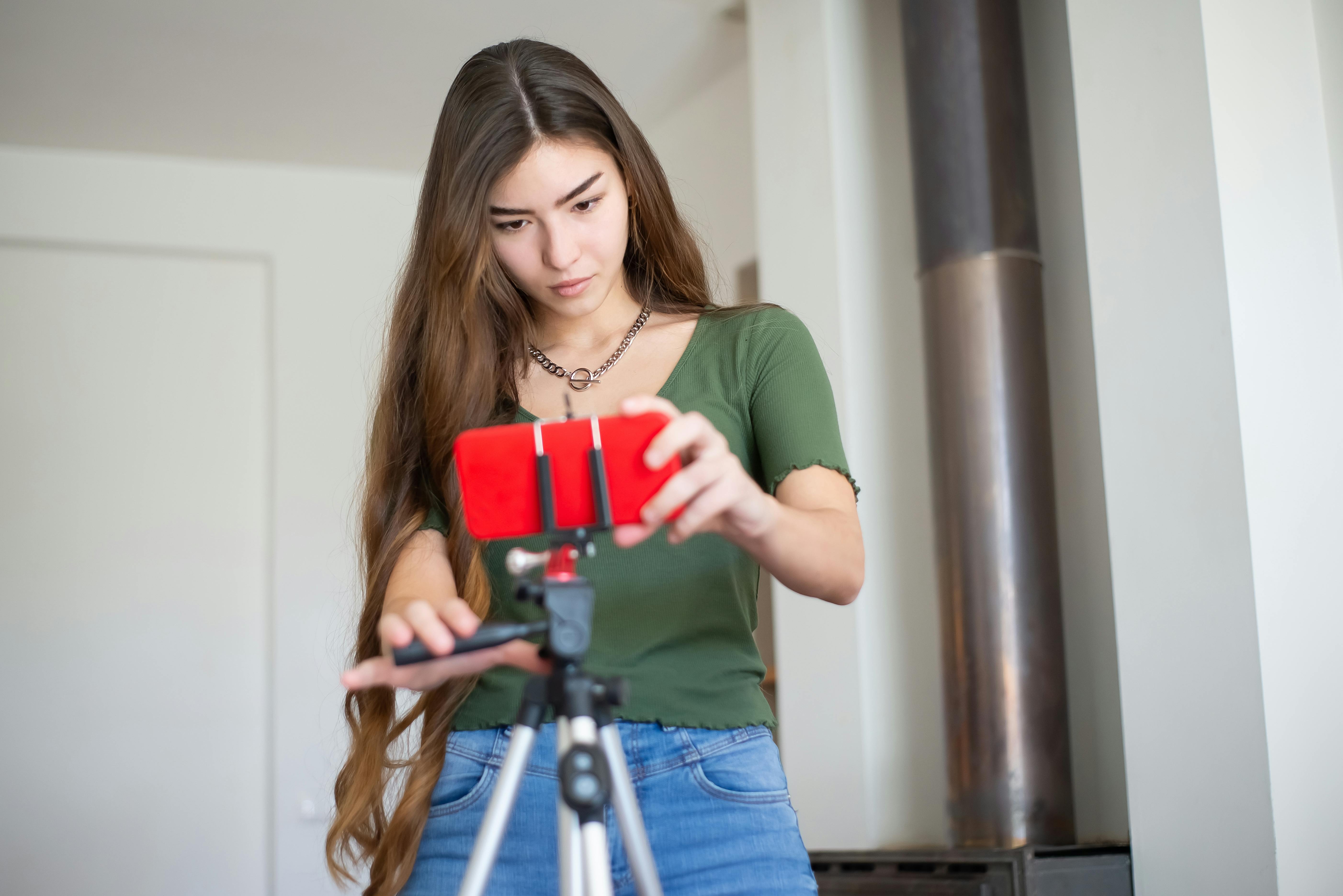 woman arranging the smartphone on a tripod