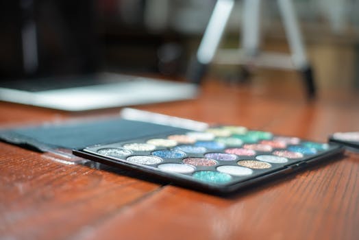 Colorful eyeshadow palette on a wooden table, ideal for beauty and makeup enthusiasts.