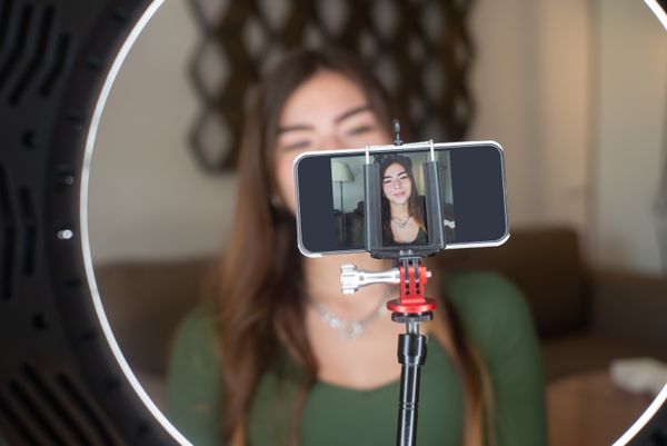 Creator live streaming from home with a phone and ring light — photo by Kampus Production on Pexels