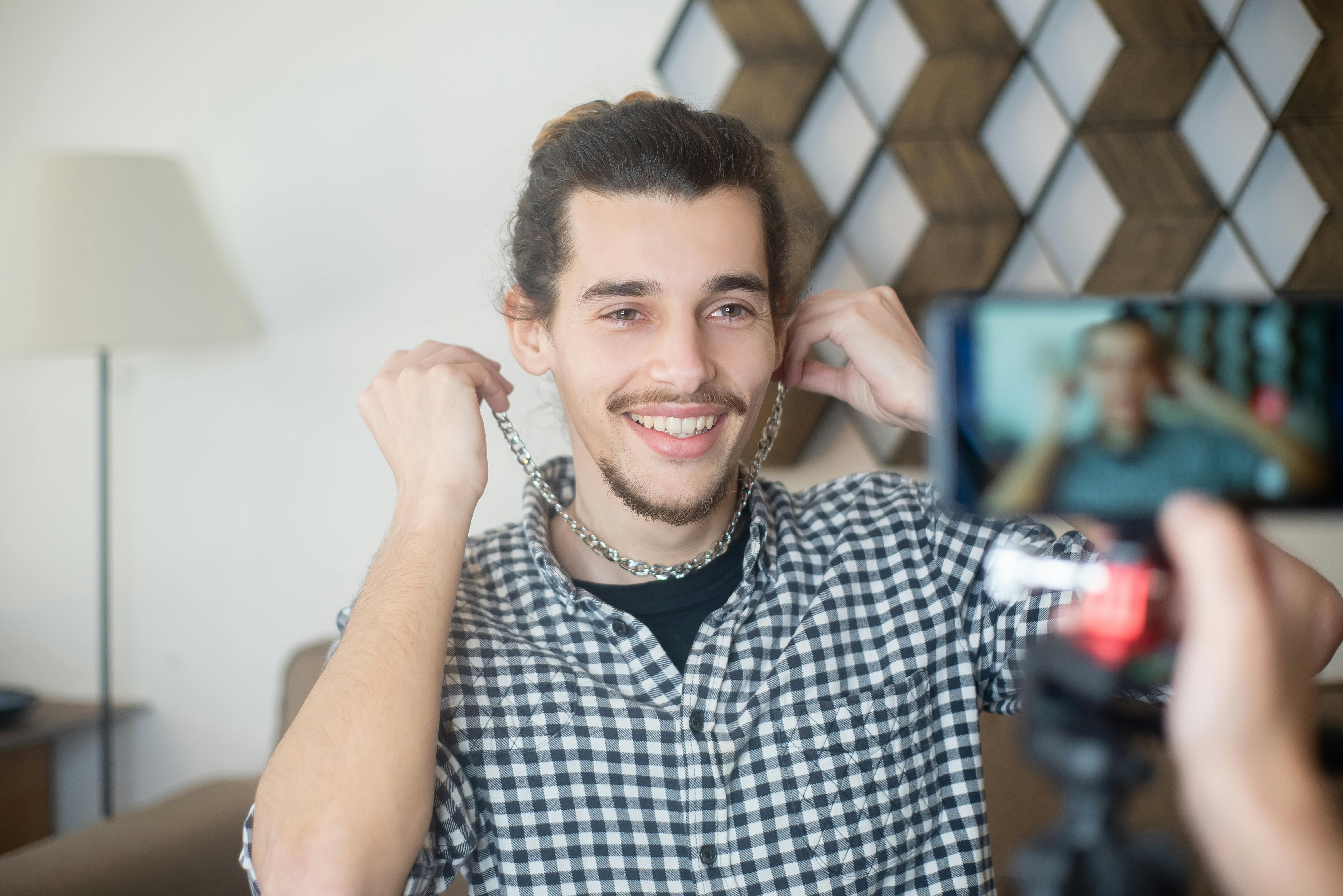 a man in checkered long sleeves wearing silver necklace