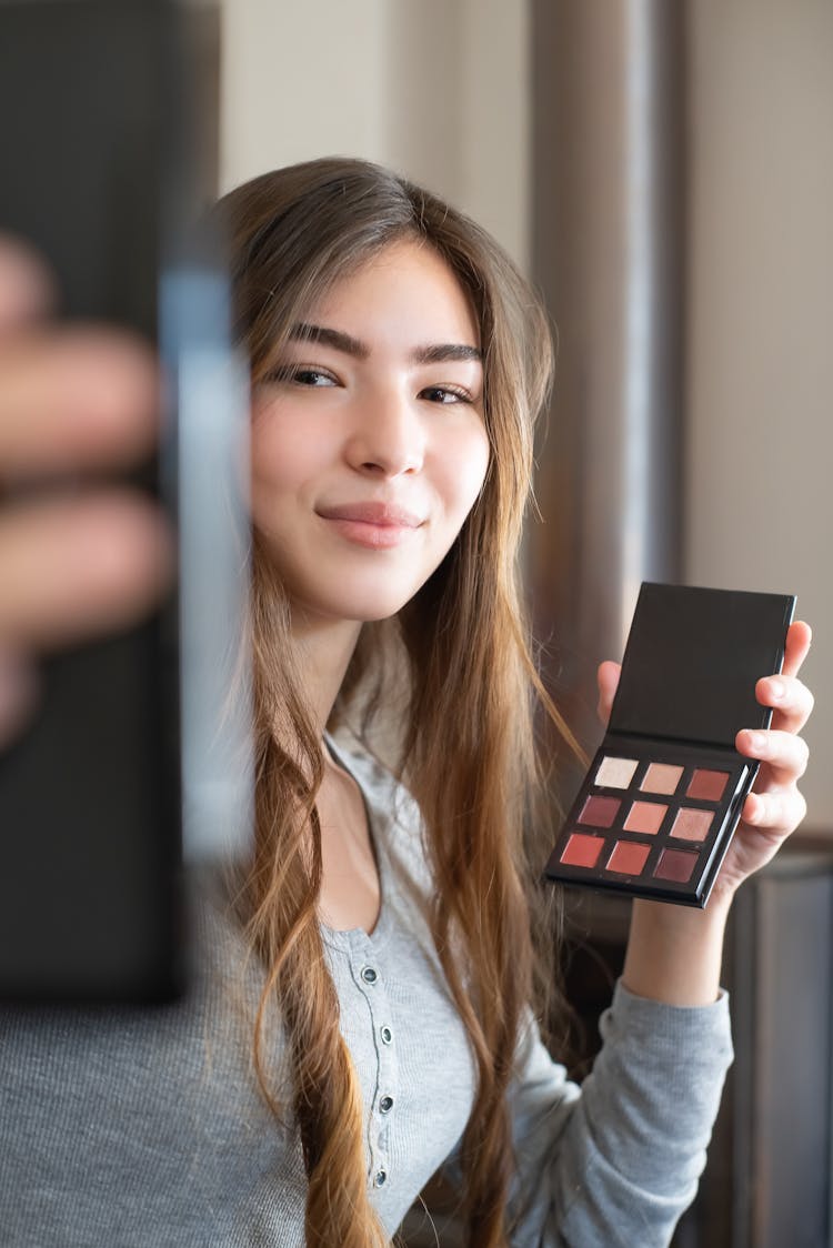 Beautiful Woman Holding A Cosmetic Product