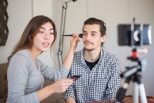 Woman applying makeup to a man during a tutorial session indoors.