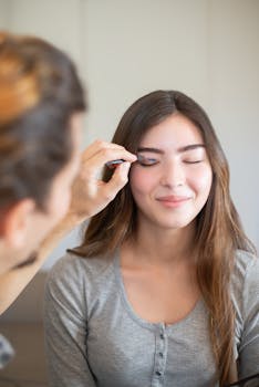 Close-up of a woman getting her makeup applied professionally with a smile.