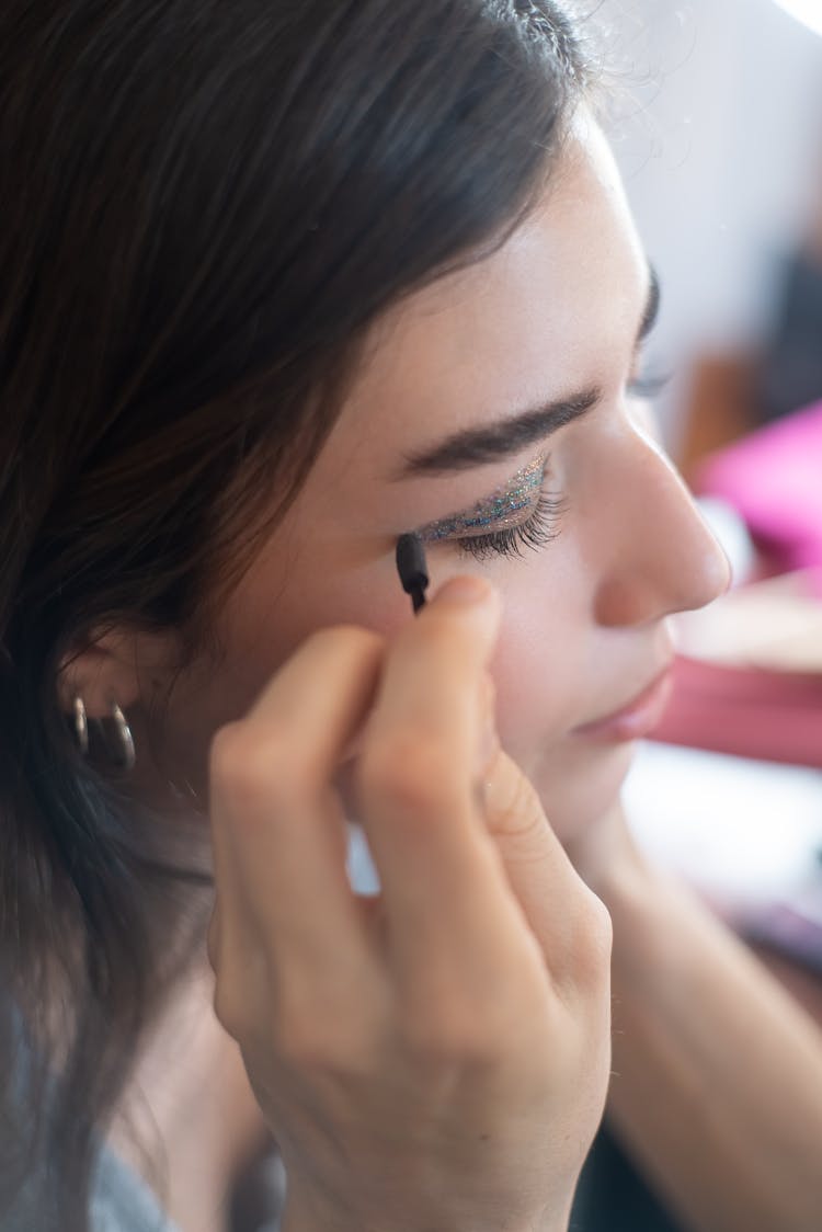 A Woman Applying An Eyeliner