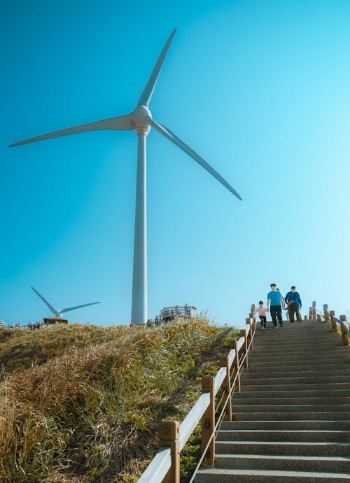 Free People Going Down the Staircase Near a Wind Turbine Stock Photo