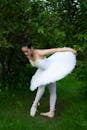 Ethnic woman in tutu dress and pointe shoes in park