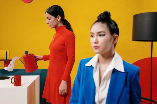 Free Two women posing in a vibrant studio with cardboard props and colorful background. Stock Photo