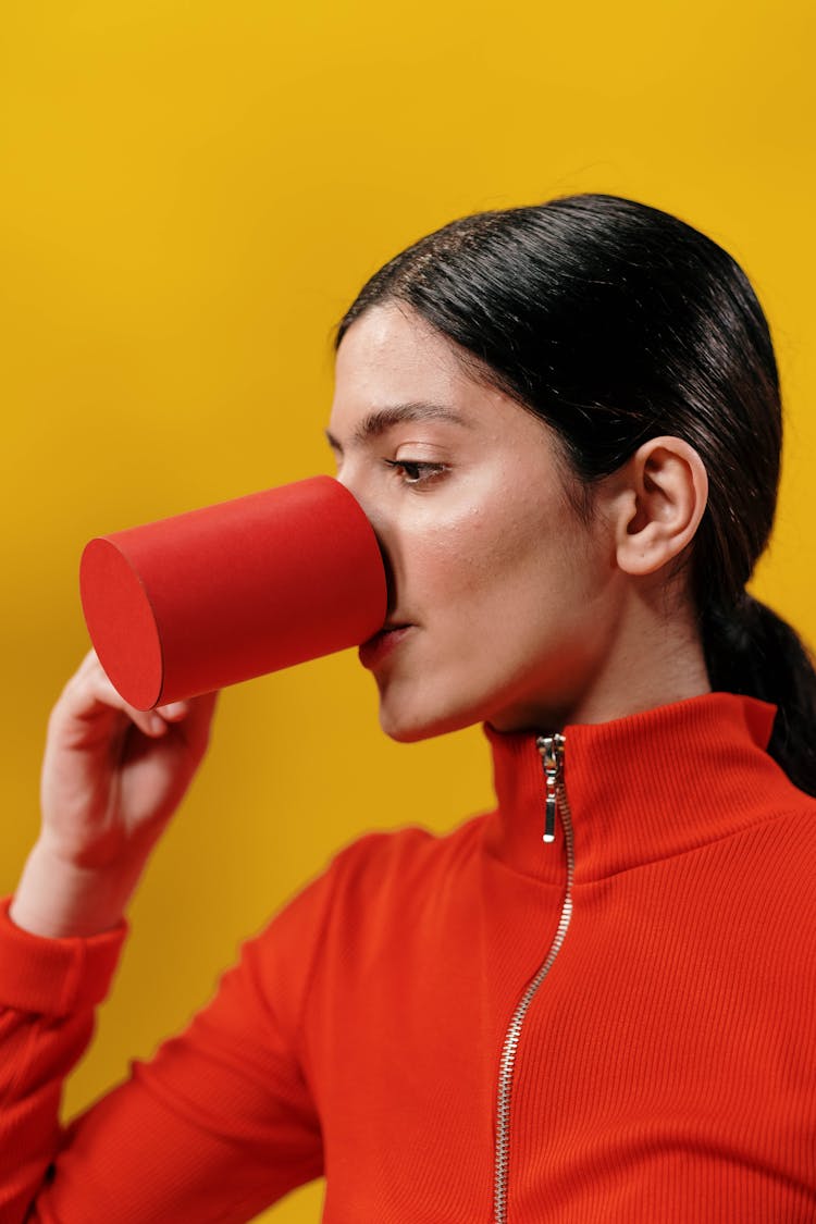 Woman In Red Long Sleeves Drinking From A Red Cup