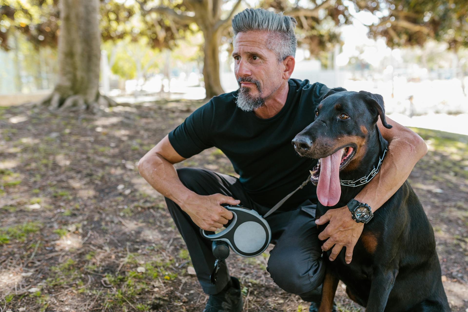 Man Crouching Beside a Dog