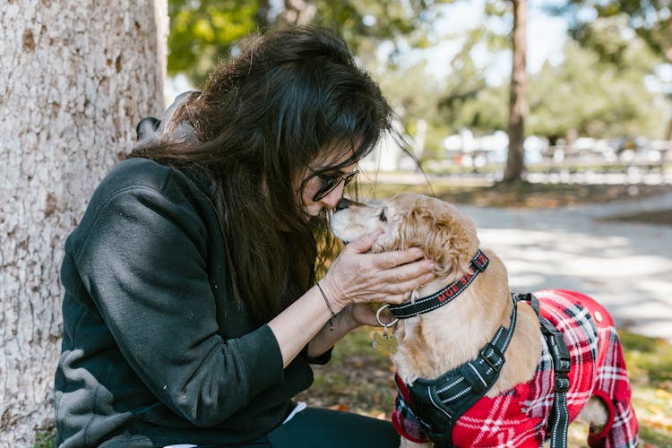 Close Up Photo Of A Woman Holding A Dog Near Her Face