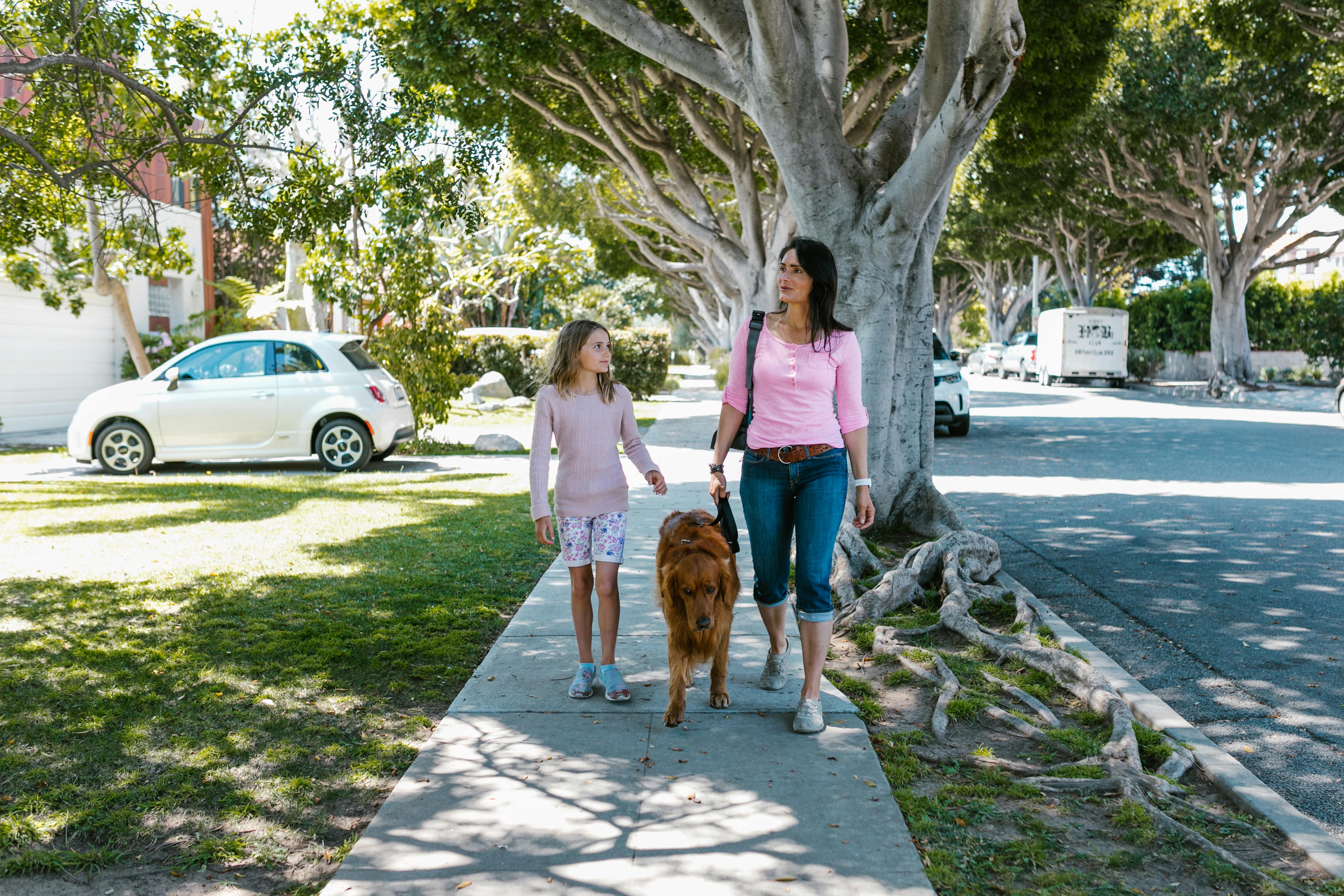 a mother and daughter walking with dog