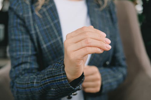 Crop faceless woman practicing sign language in cafe