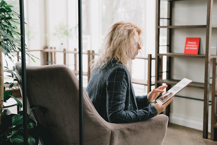 Focused Elegant Businesswoman Working On Tablet In Office