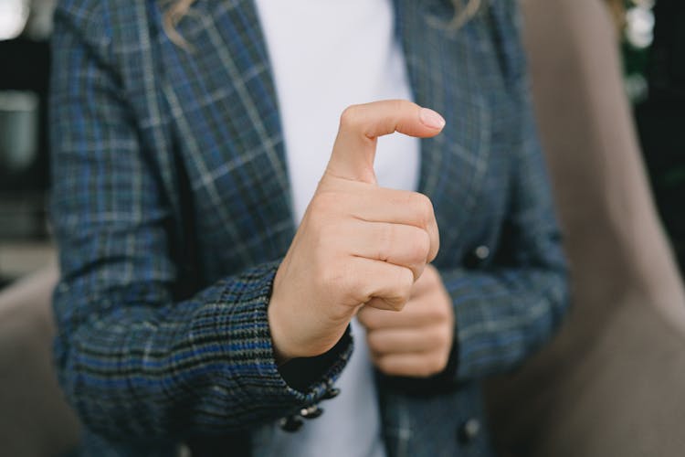 Crop Faceless Woman Showing Sign With Finger While Sitting In Cafe