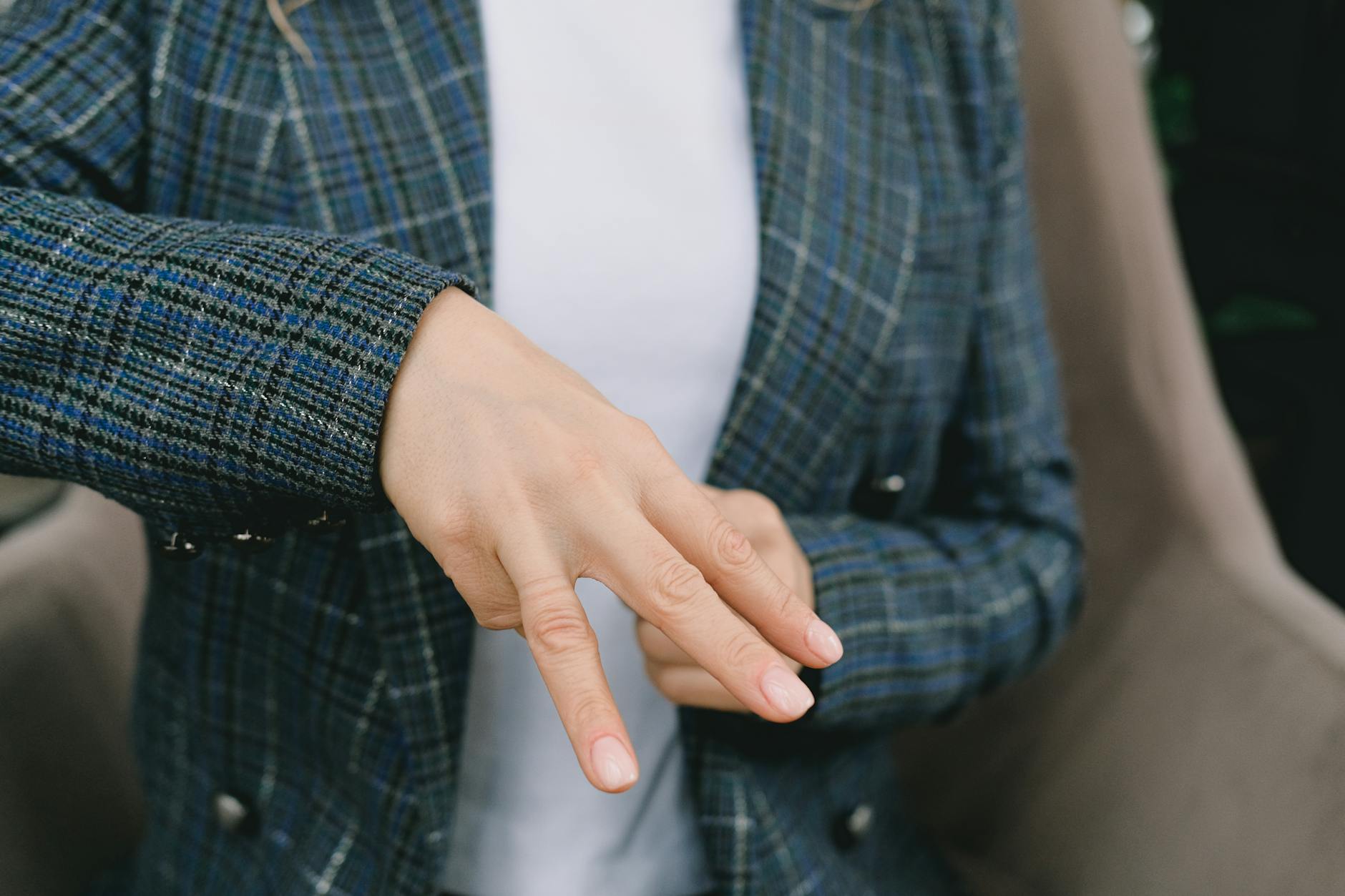 woman closely examining the construction and fabric of a tailored blazer