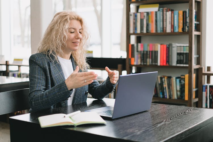 Smiling Woman Having Video Chat Via Laptop In Library