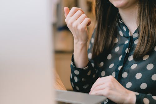 Crop self employed lady using laptop during online work