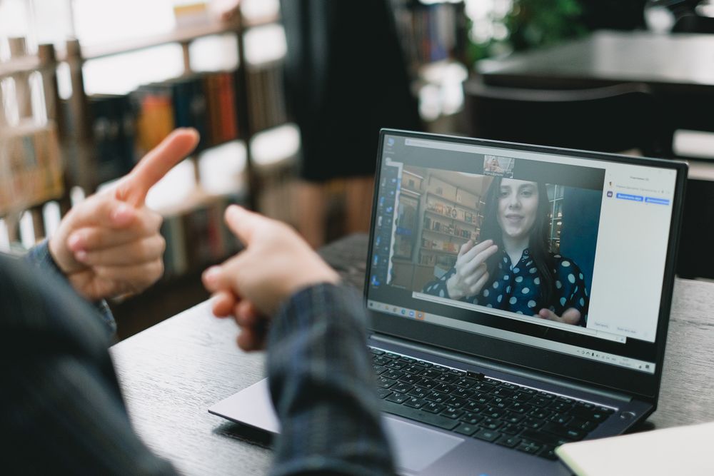 A Deaf adult learning skills in an online lesson with a signing tutor