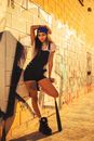 Woman in Black Tank Top and Black Shorts Leaning on Wall