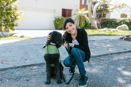 Woman Smiling Beside a Black Dog