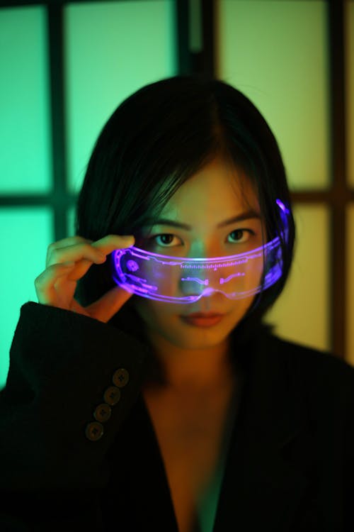 Asian woman in futuristic glowing eyeglasses