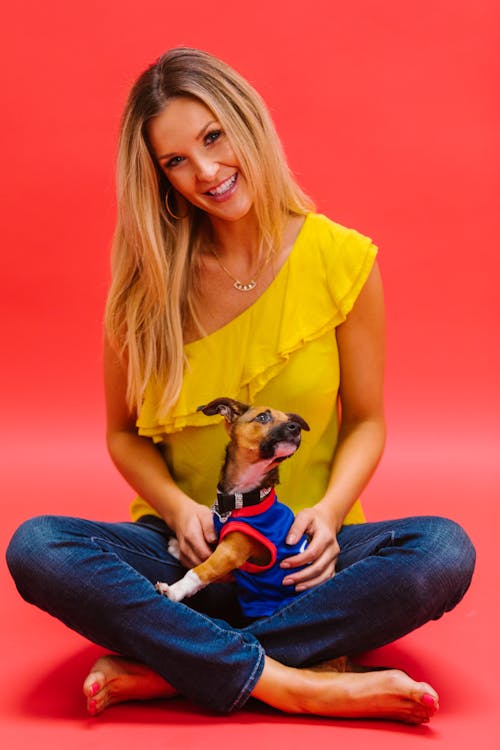 Free Woman in Yellow Top Holding her Dog Stock Photo