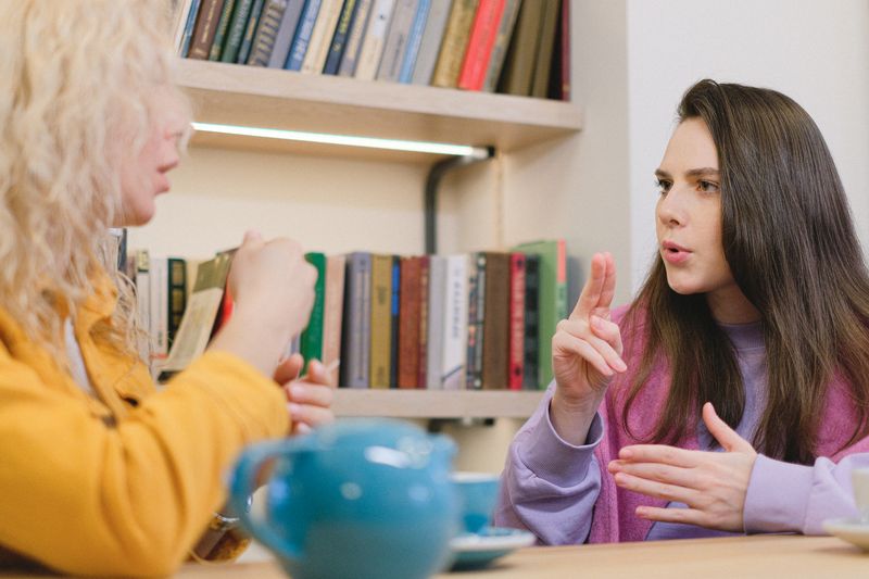 Friends communicating in sign language at a library