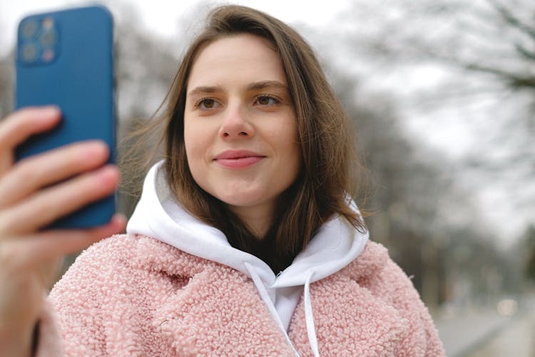 Smiling Woman Taking Selfie On Smartphone