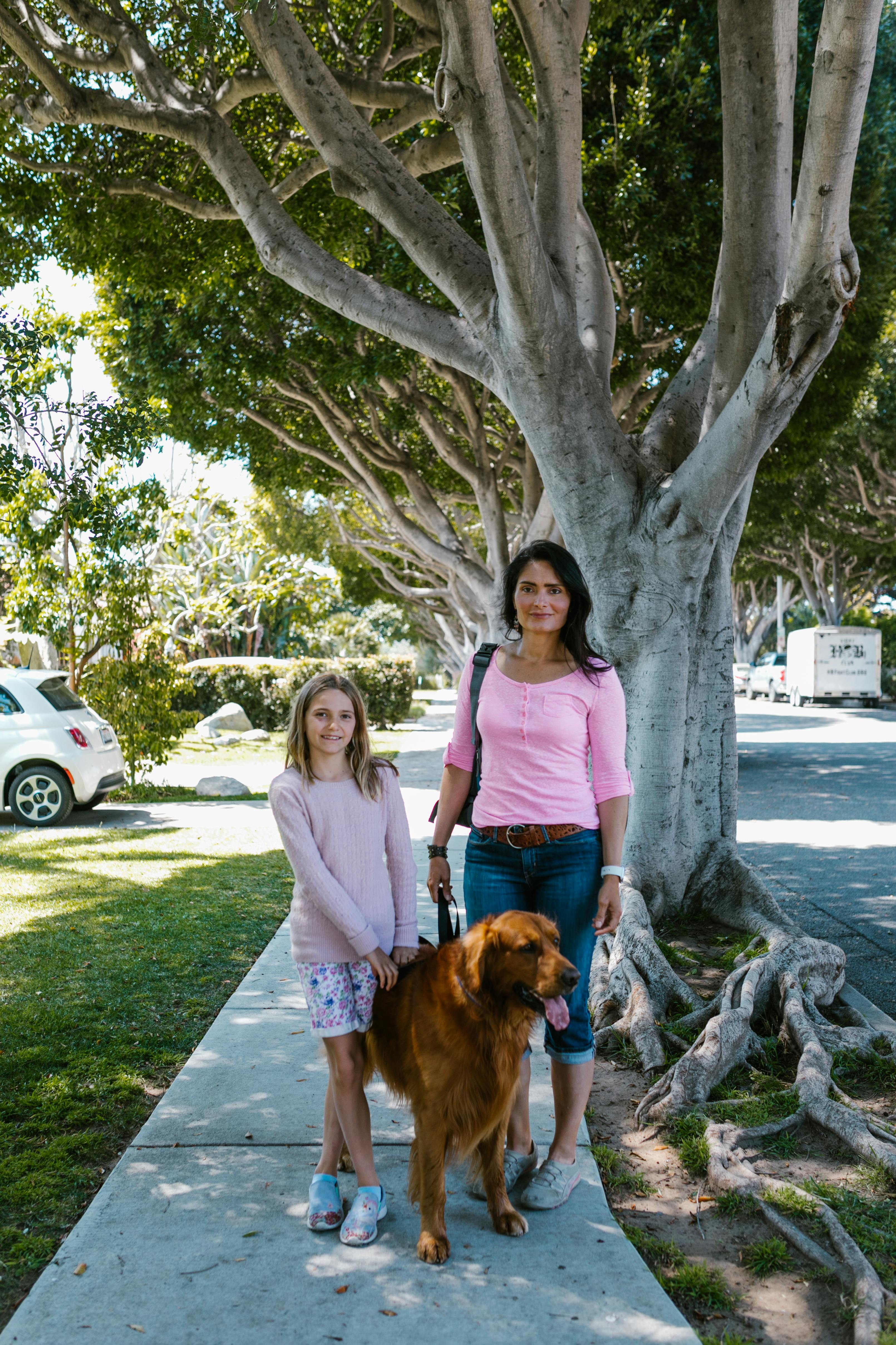 mother and daughter standing beside a dog