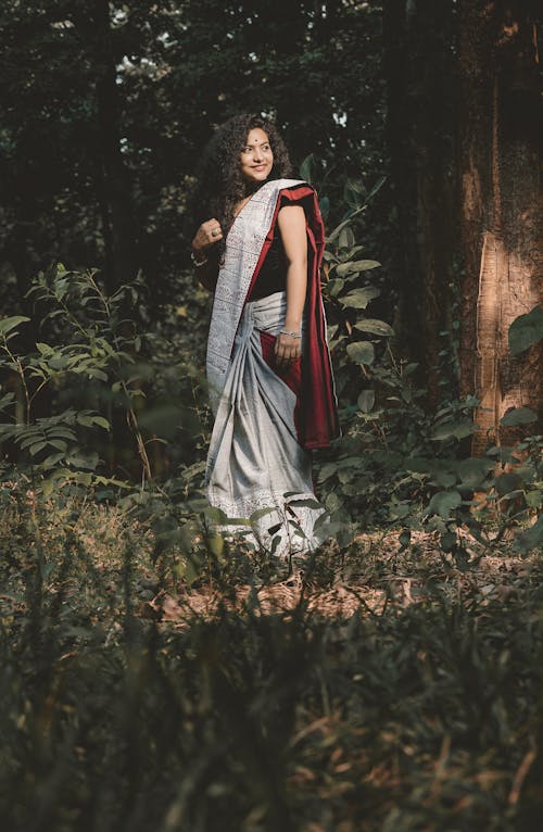 A Woman in a Saree Standing in the Middle of the Forest