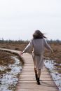 Woman walking on wooden path in windy weather in spring