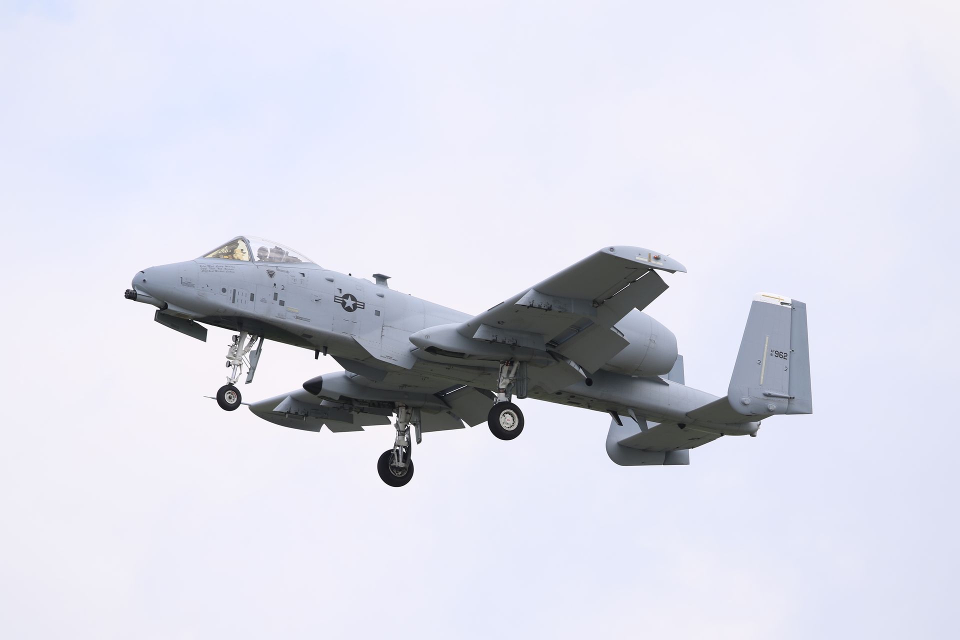 Avión de combate en vuelo bajo cielo gris nublado