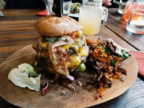 Mouthwatering cheeseburger topped with bacon, served with crispy vegetables on a rustic wooden plate.