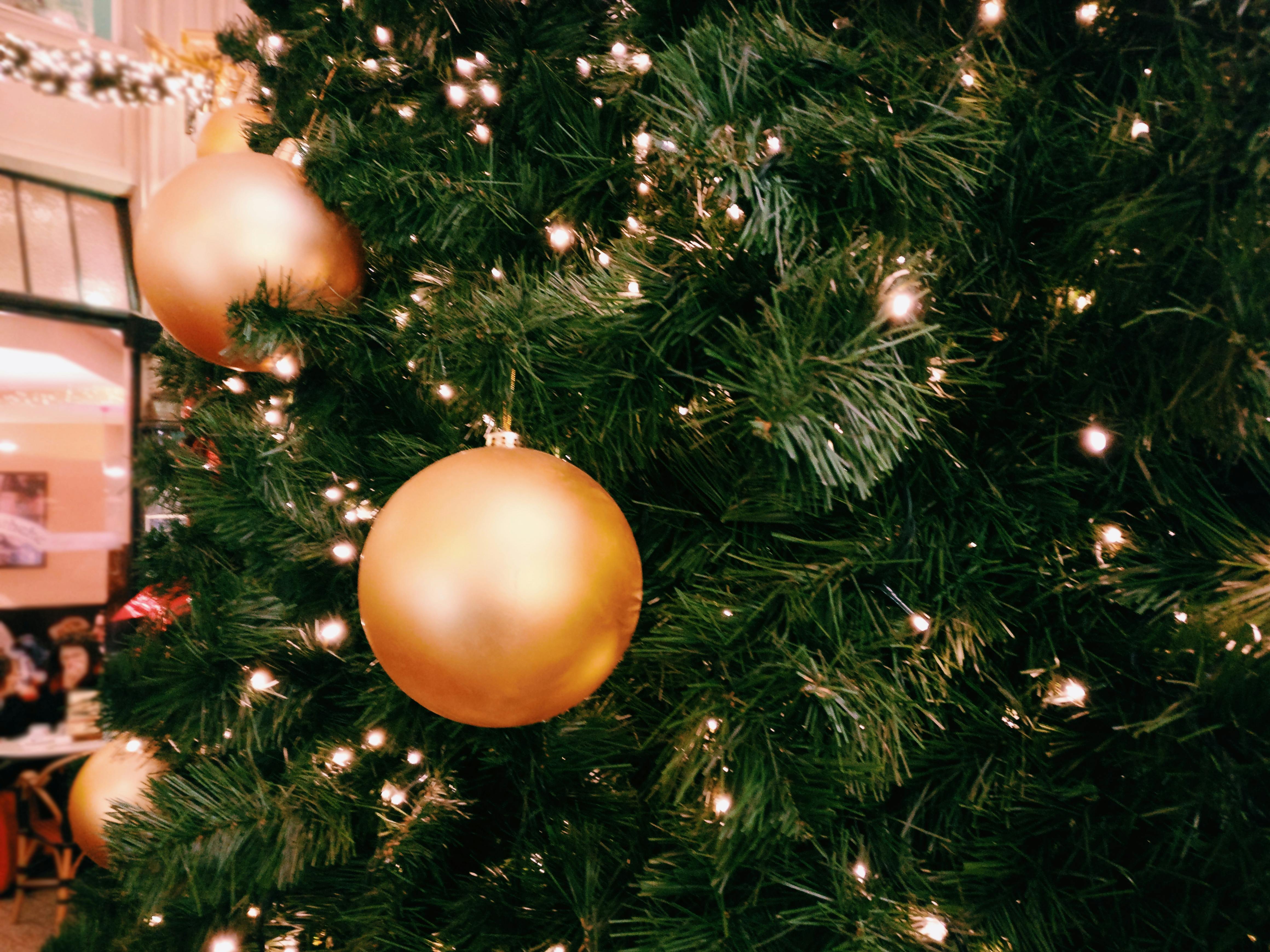 green christmas tree with three round gold ornaments