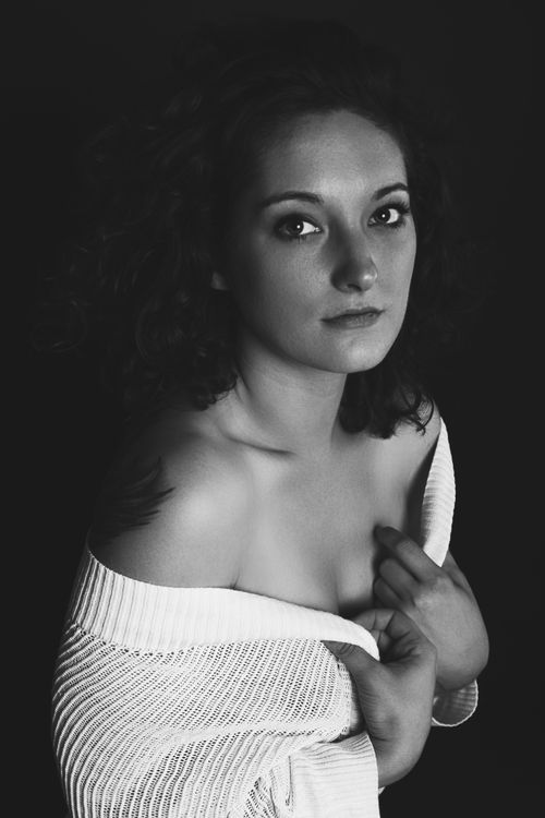 Free Artistic black-and-white portrait of a woman in a studio setting, exuding elegance and grace. Stock Photo