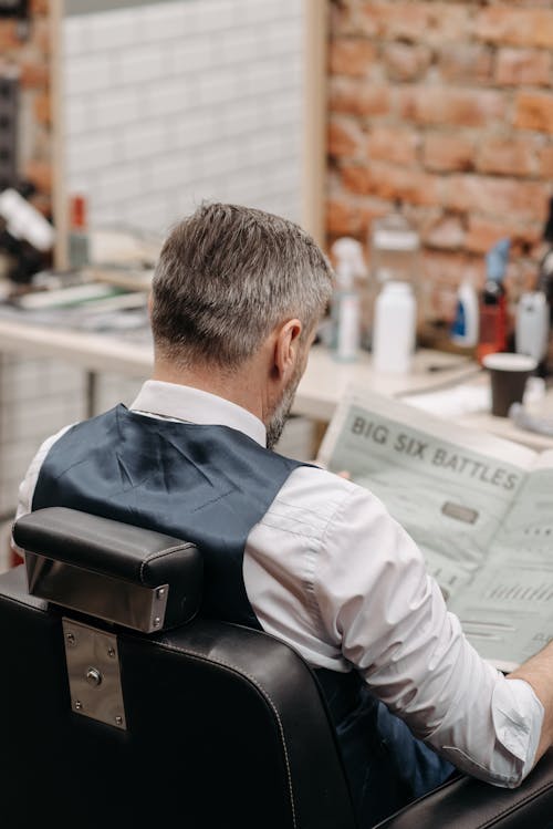 Free Man Sitting on Chair Reading a Newspaper  Stock Photo